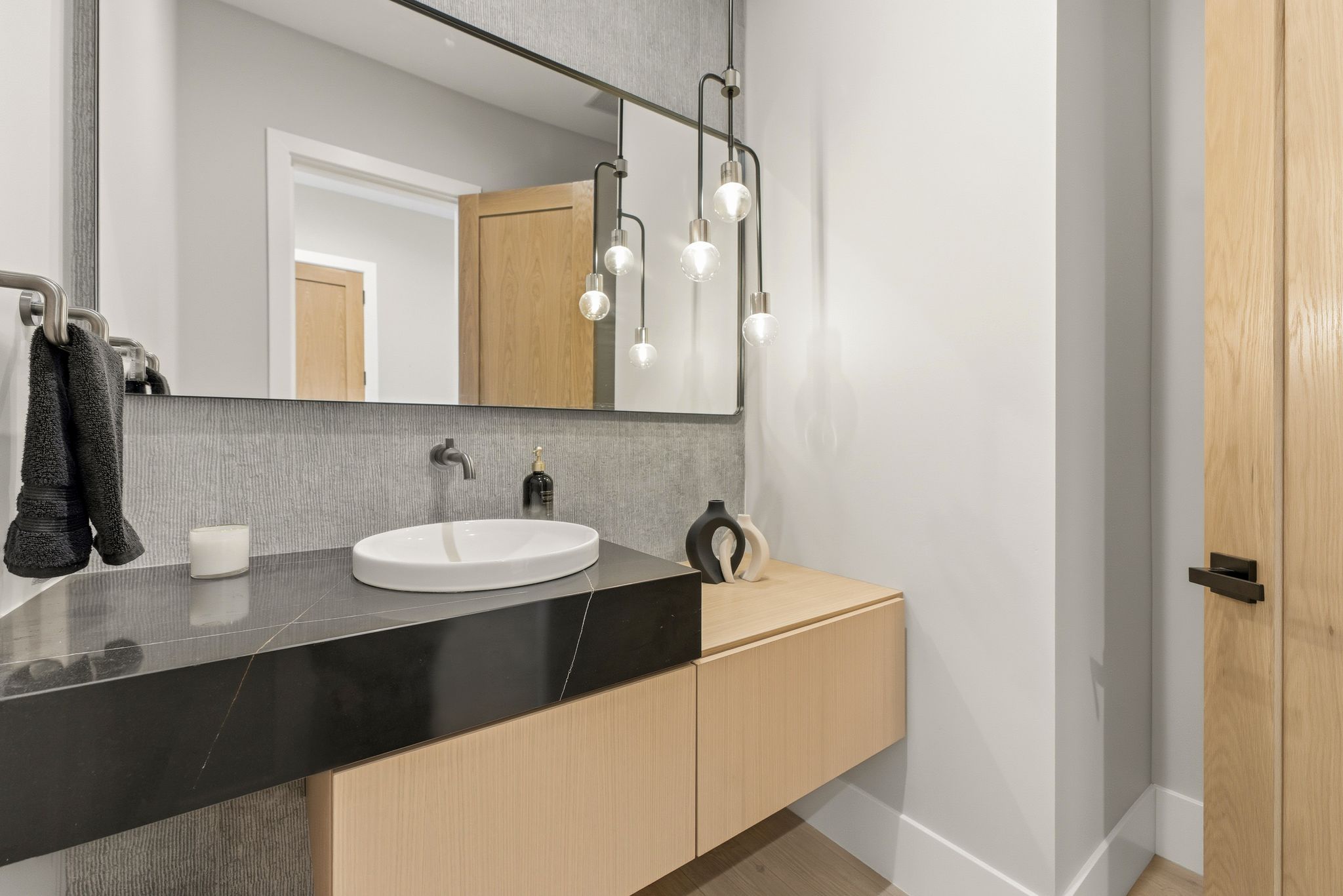 Contemporary bathroom vanity featuring a rectangular black stone countertop with white veining
