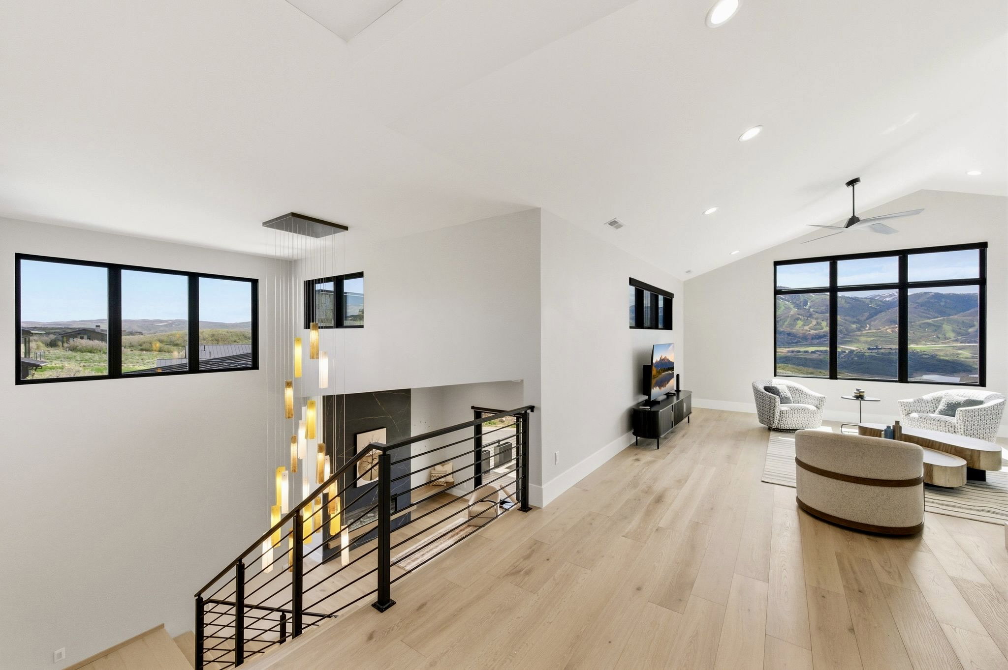 Upper level living area with vaulted ceilings and wood-finish flooring