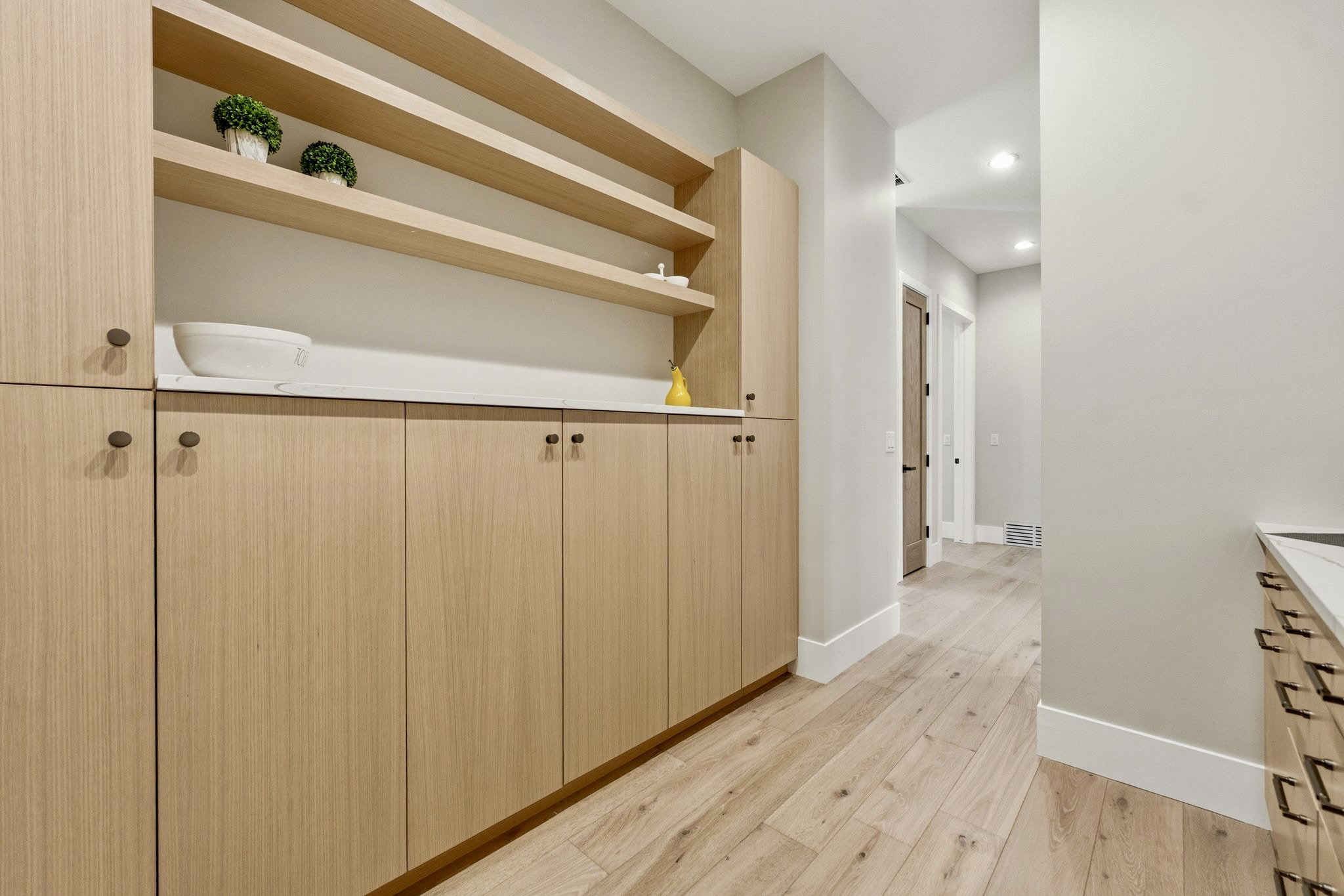 Custom cabinetry featuring wood-finish doors and open shelving, complemented by a light-toned countertop