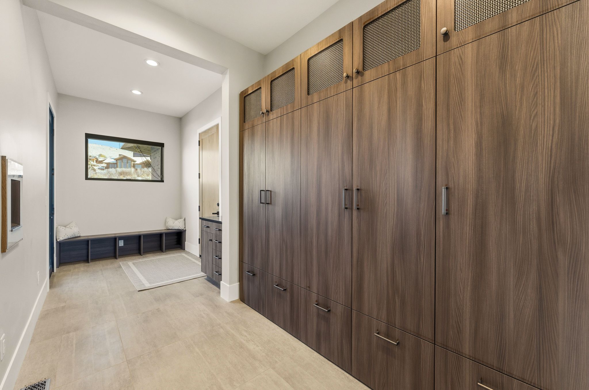 Hallway featuring floor-to-ceiling wood-finish cabinetry with integrated hardware