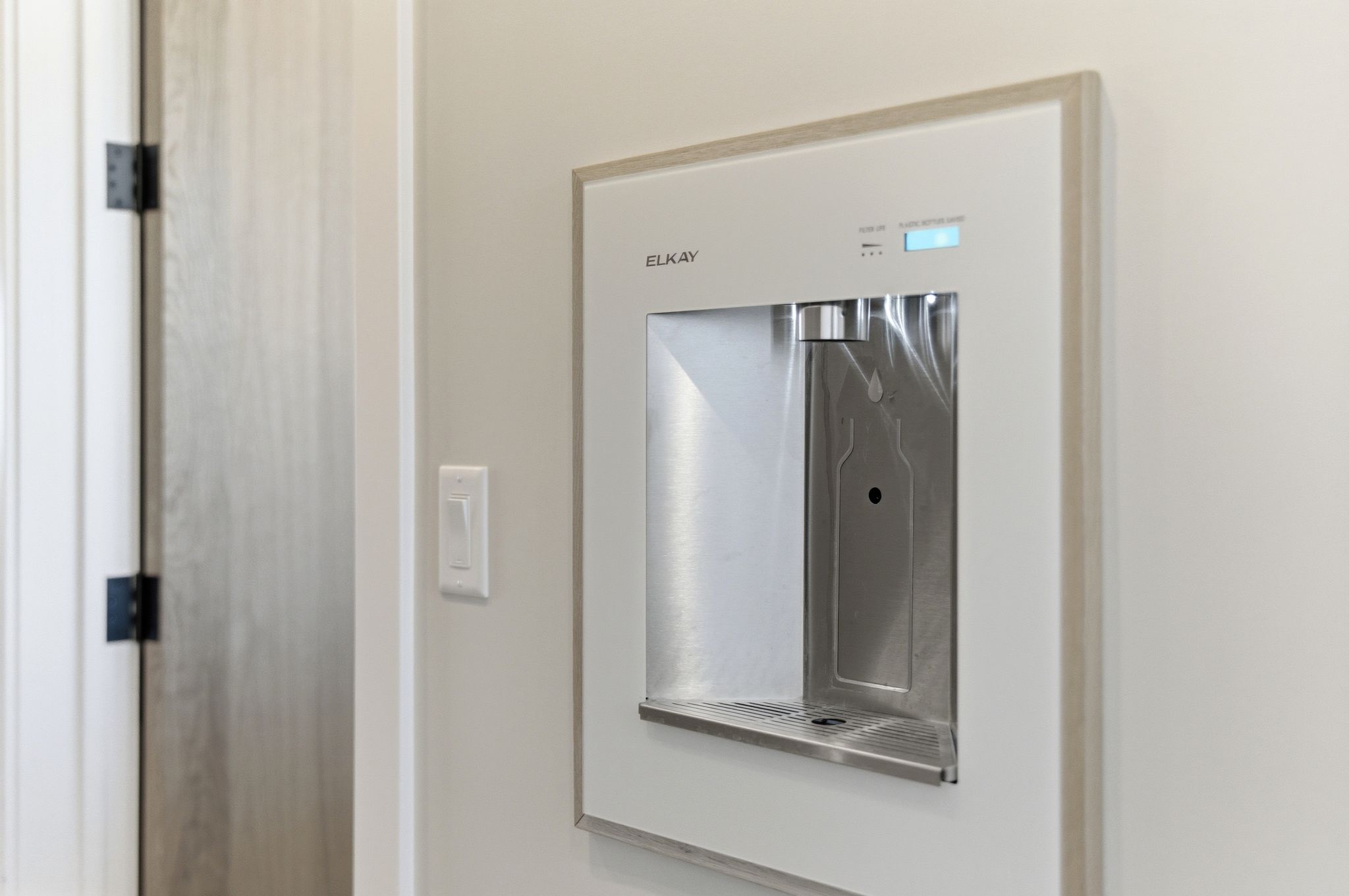 Built-in water dispenser featuring a stainless steel basin and bottle-fill capability