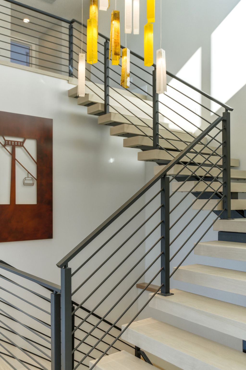 Floating staircase with light wood-finish treads and contemporary black metal railings