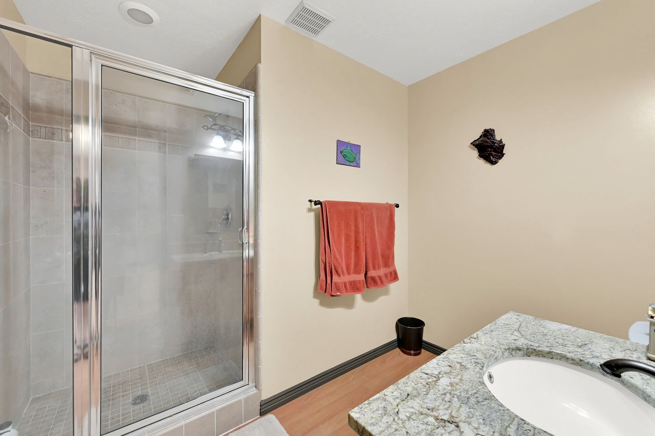 Shower with chrome-framed glass enclosure and tiled walls