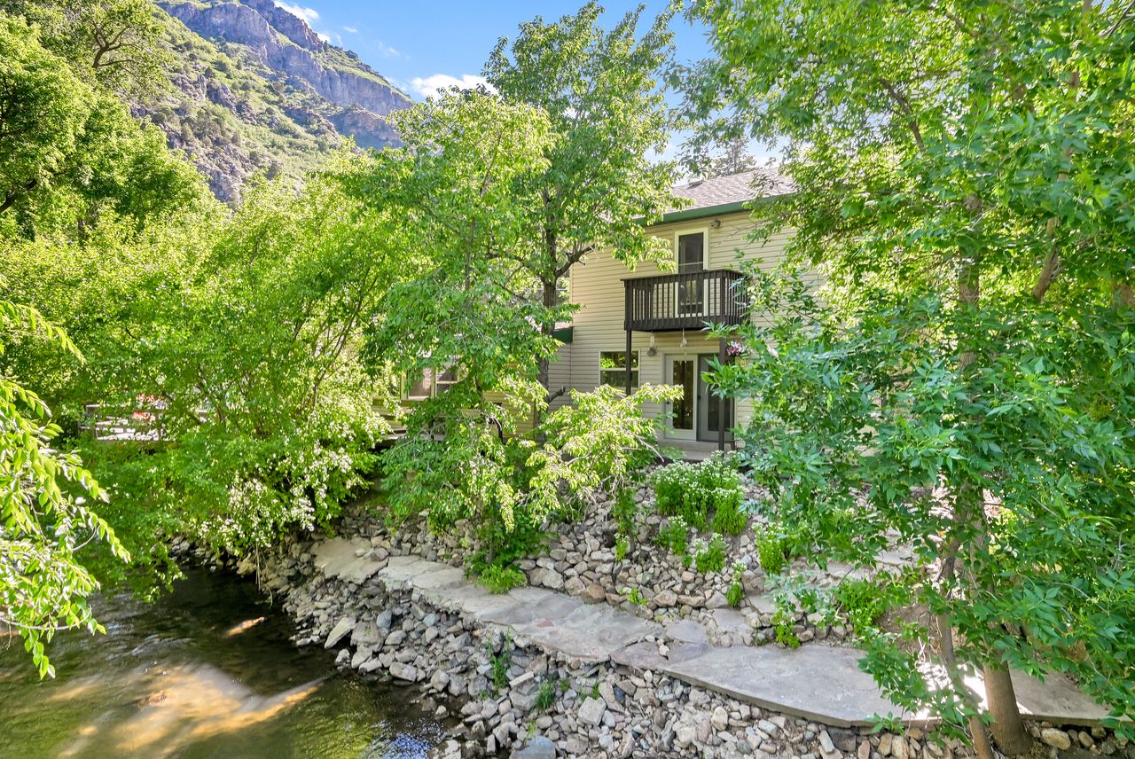 Riverside property with multi-level outdoor access, featuring a private balcony and ground-level patio