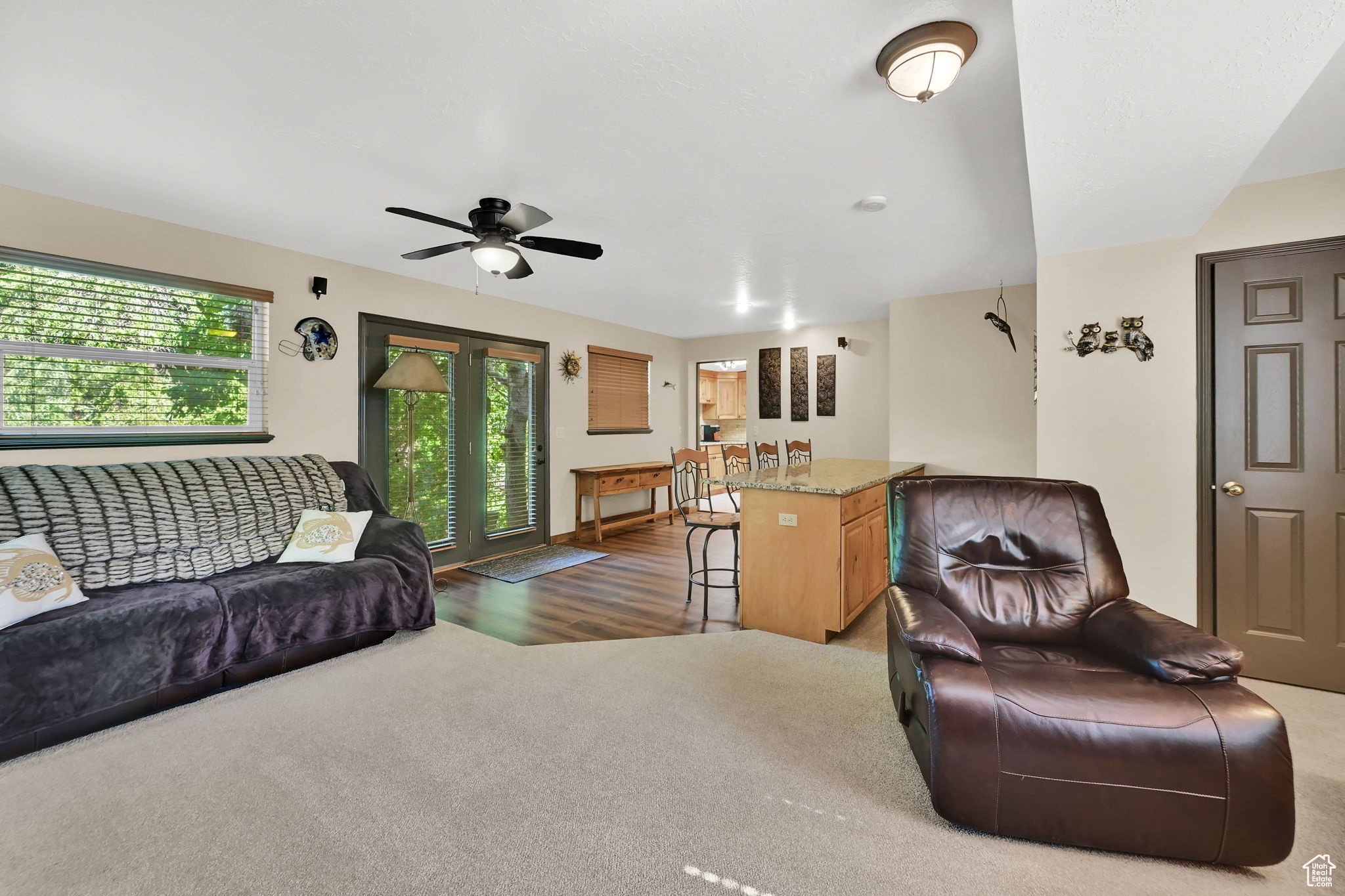 Spacious living area featuring light carpeting and wood-finish flooring