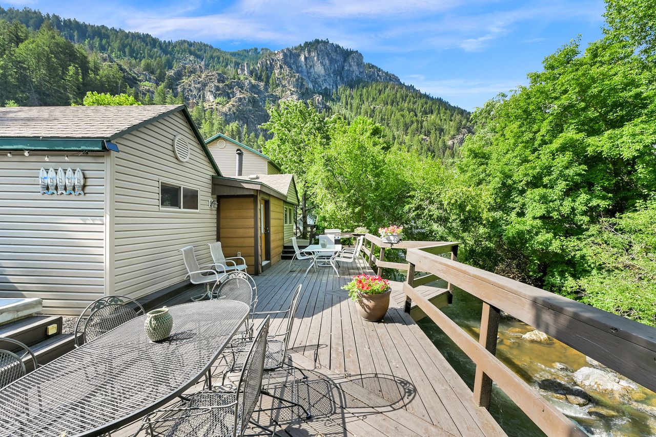 Expansive wood deck with a natural wood railing overlooking a flowing river