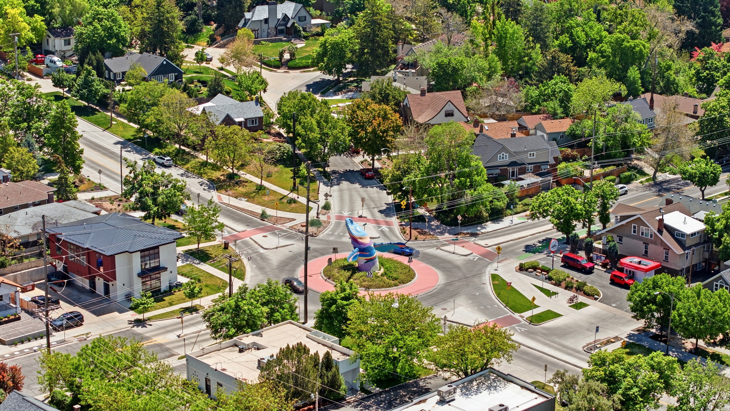 Aerial perspective showcasing a vibrant neighborhood with a central roundabout and tree-lined streets