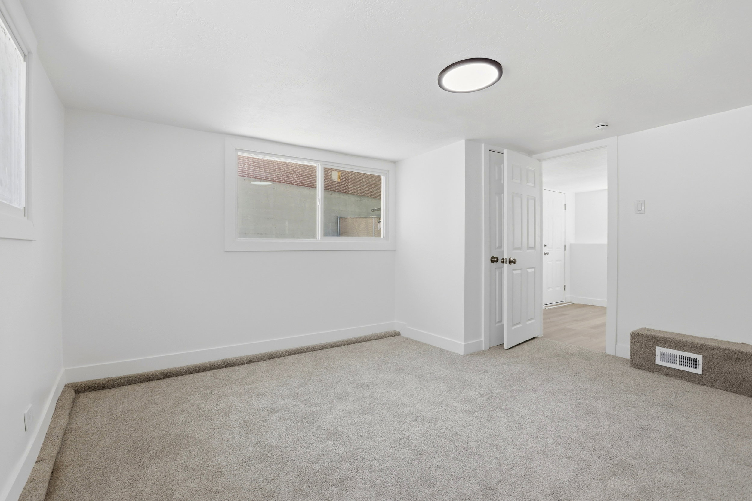 Neutral-toned carpeted room featuring white walls and trim