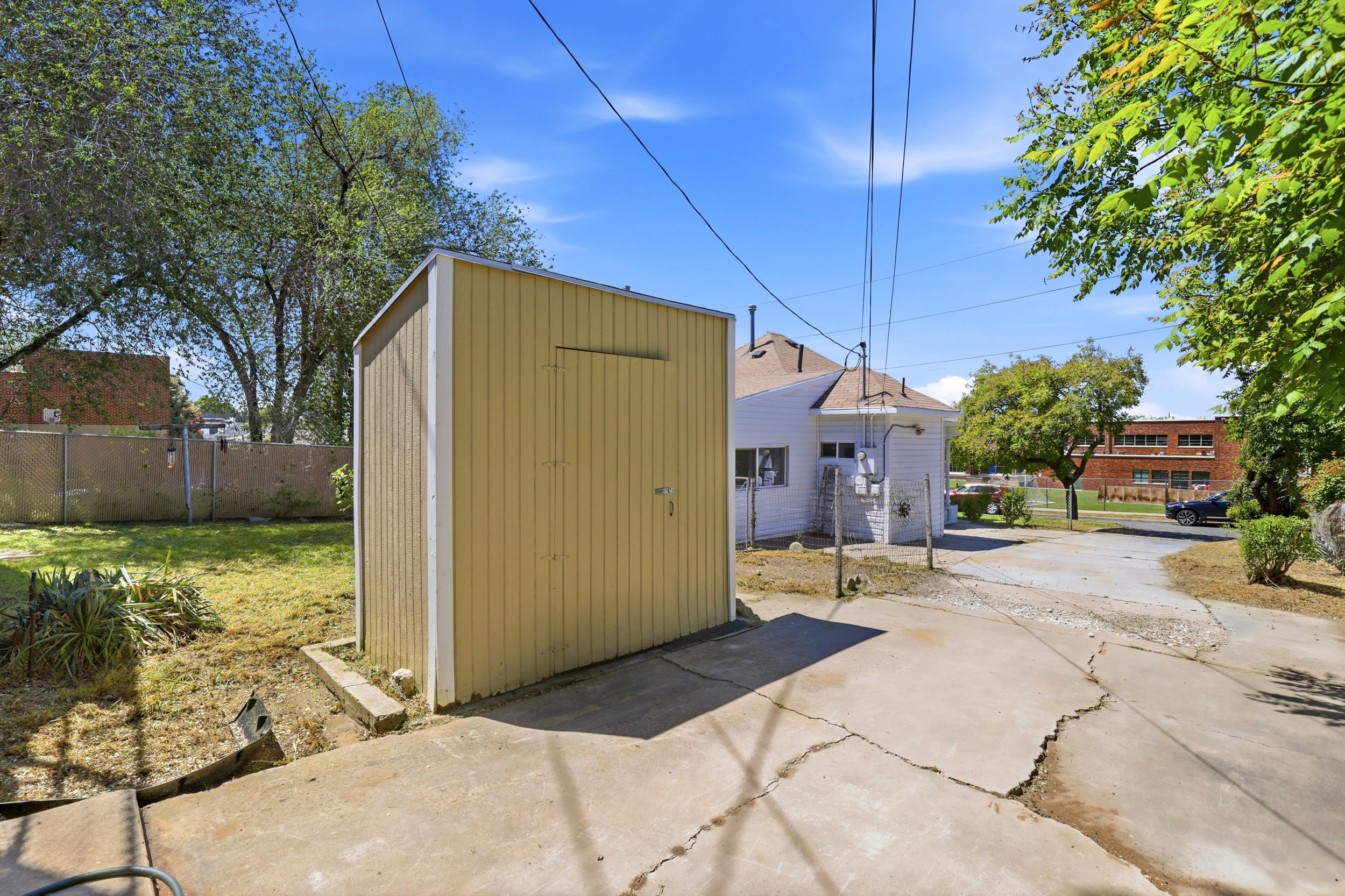 Detached shed with vertical siding, pitched roof, and a side access door