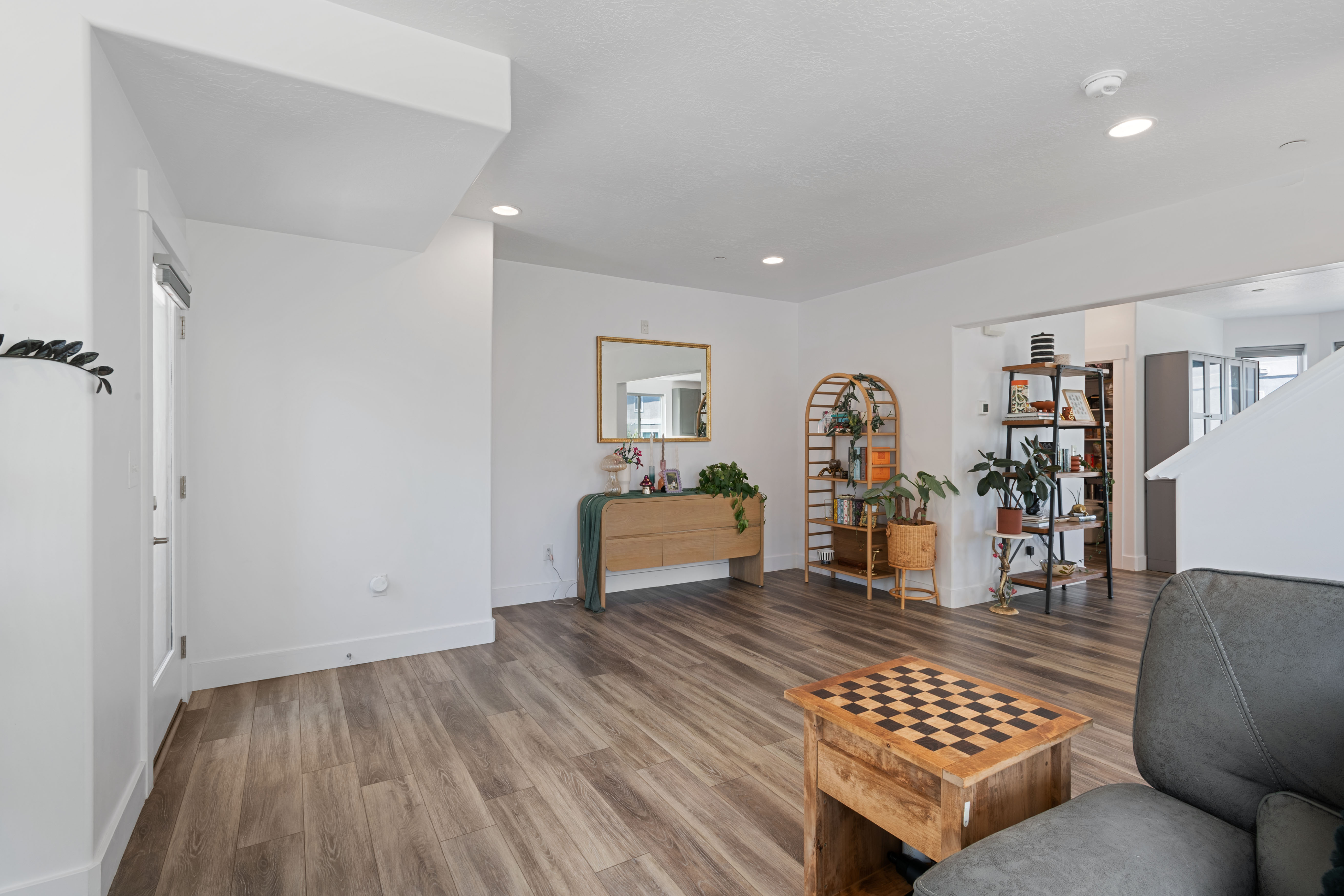 Spacious living area featuring wood-finish flooring, recessed lighting, and white baseboards