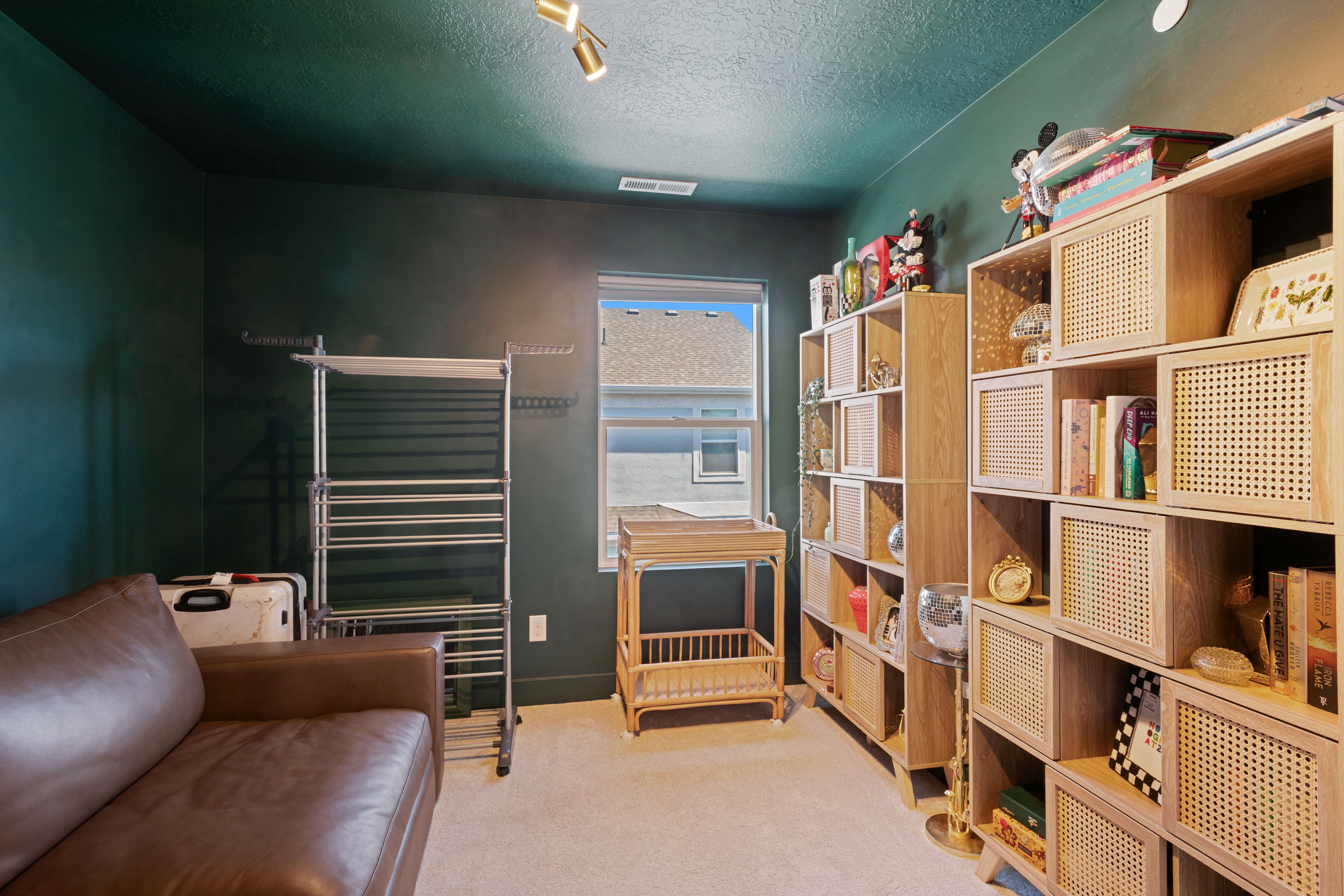 Room featuring textured dark green walls and a complementary ceiling