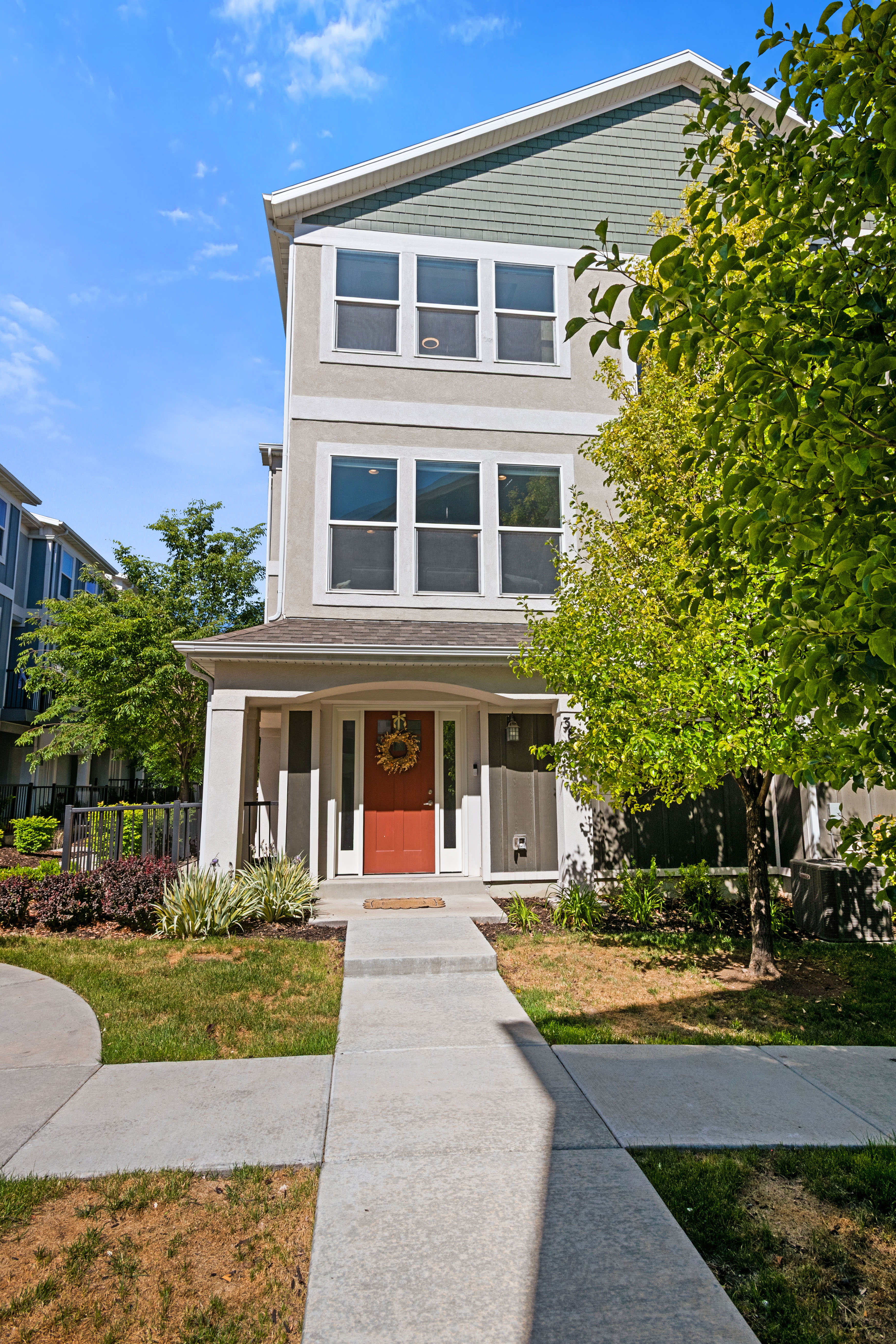 Three-story townhouse featuring a stucco and siding exterior