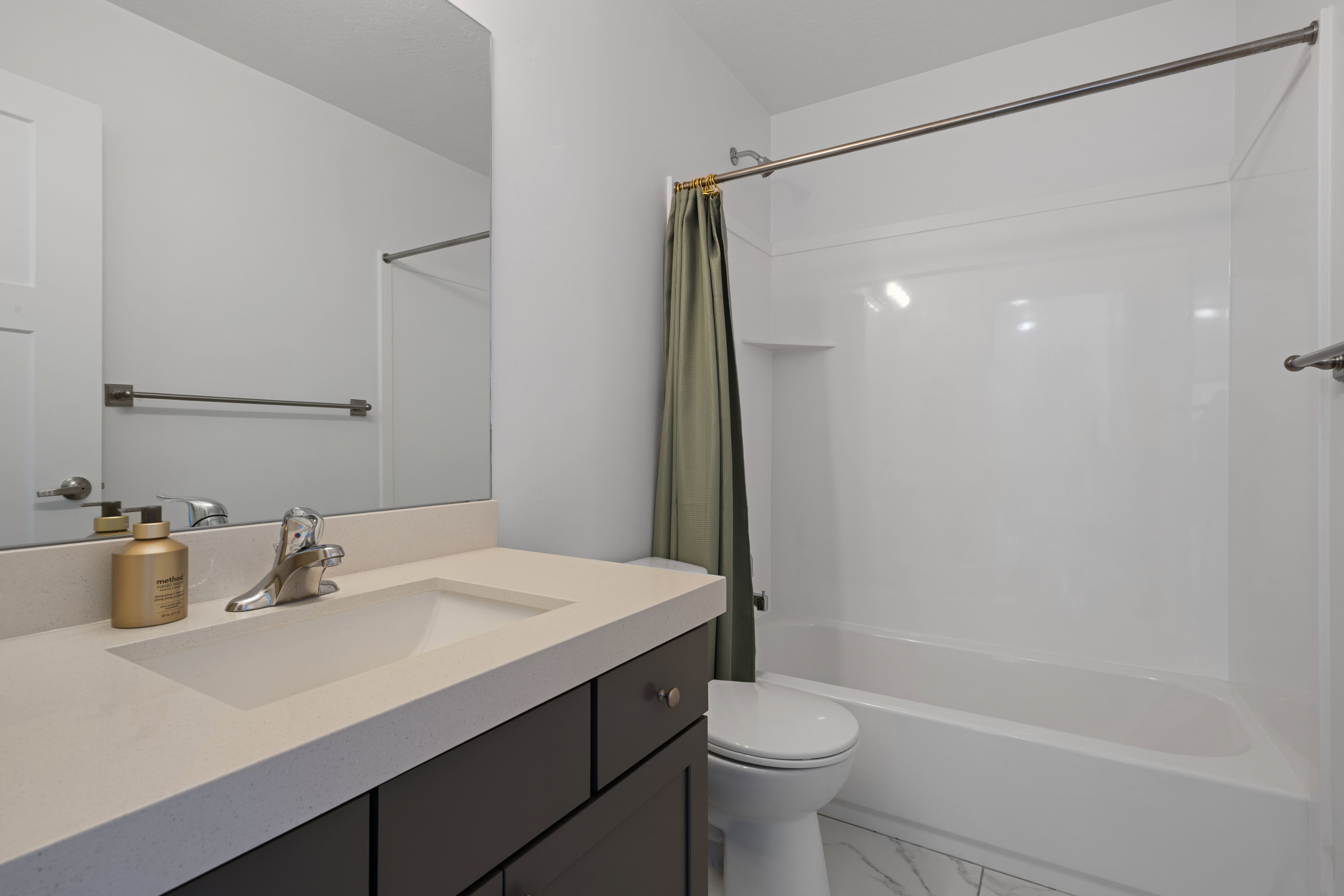 Bathroom featuring a white integrated sink, light-colored countertop, and dark-finish vanity with drawer storage