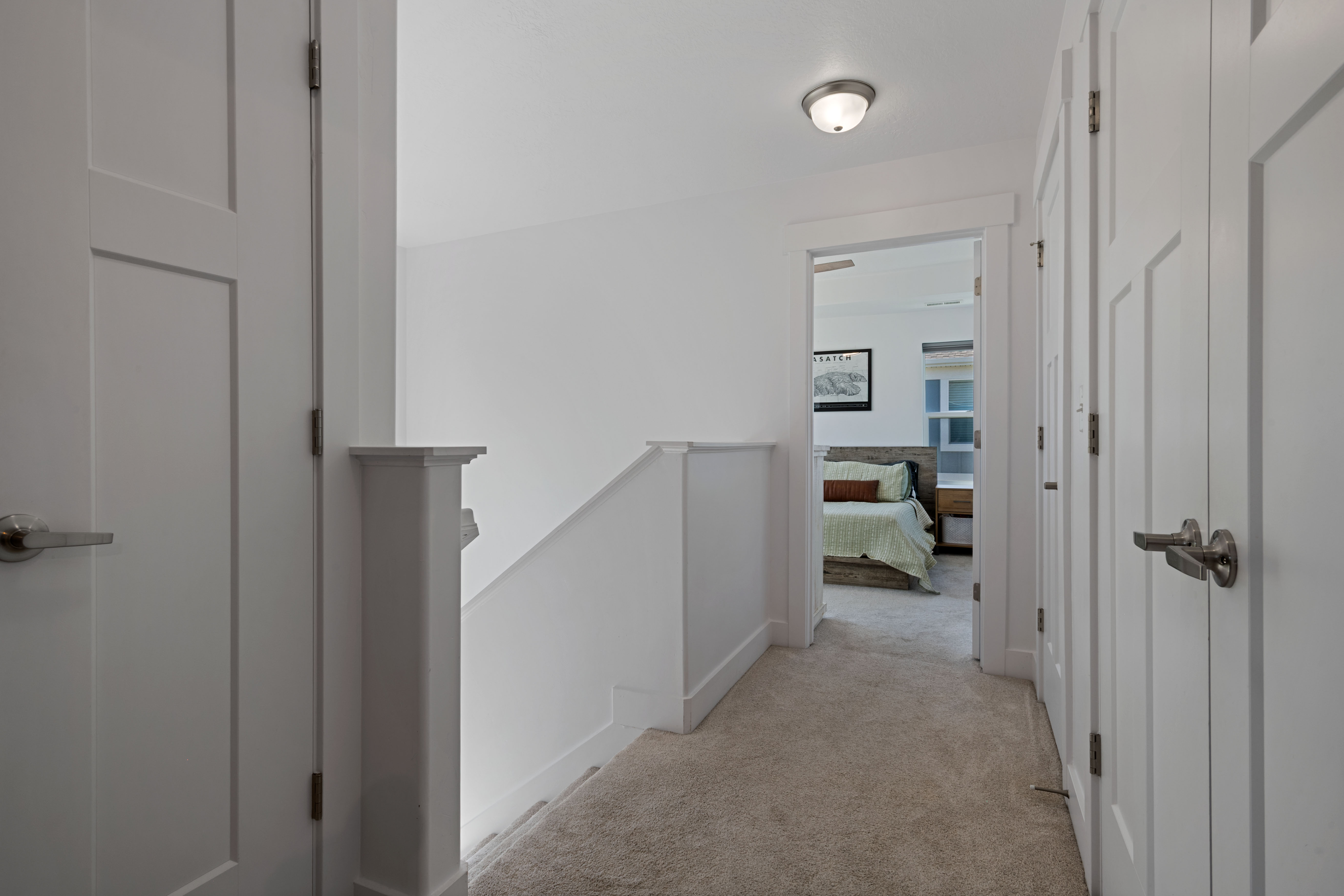 Hallway featuring a neutral carpet, white walls, and bright white trim