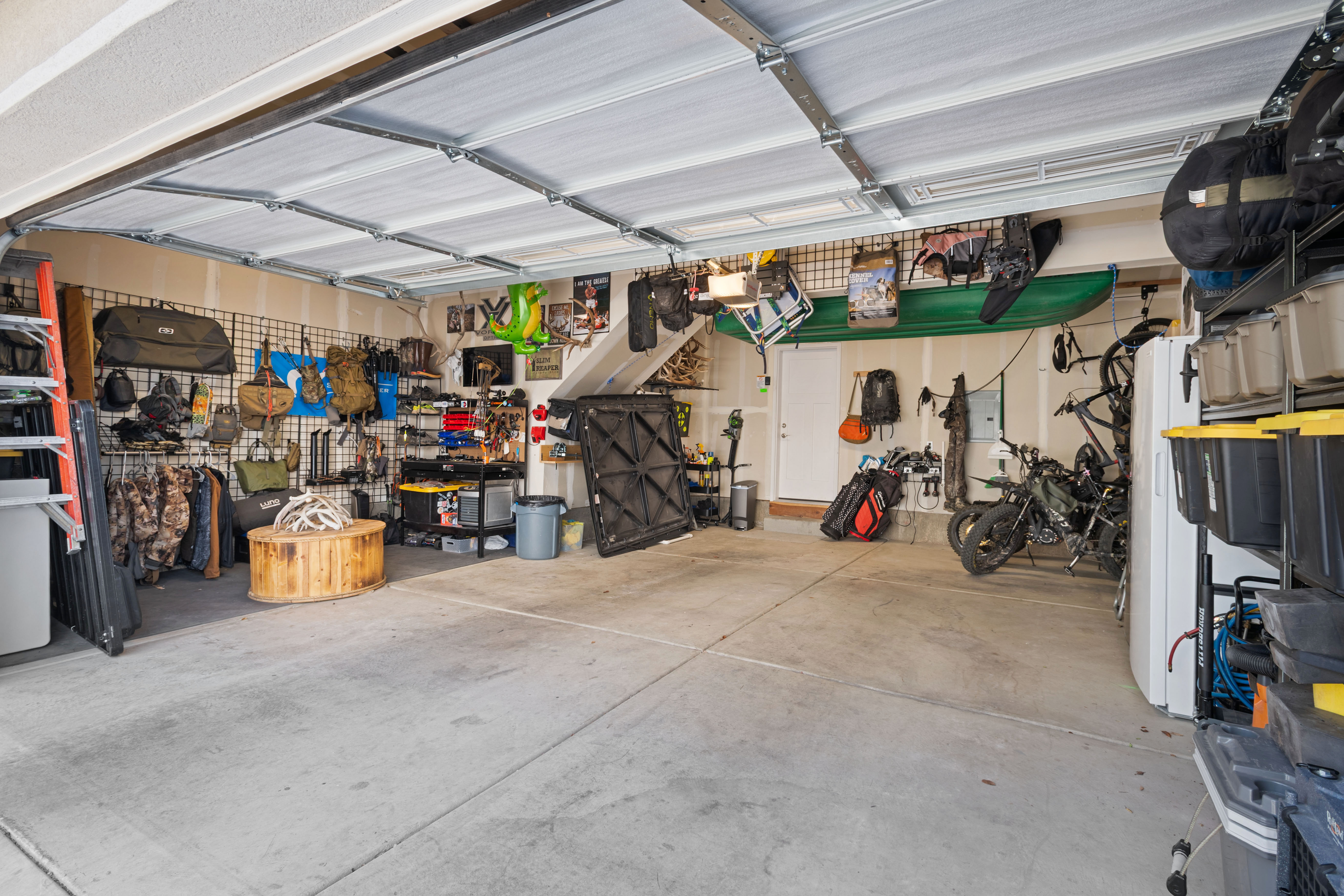 Spacious two-car garage featuring a concrete floor, white walls, and an open garage door