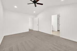 Spacious room featuring vaulted ceilings, recessed lighting, a ceiling fan, and plush carpet flooring