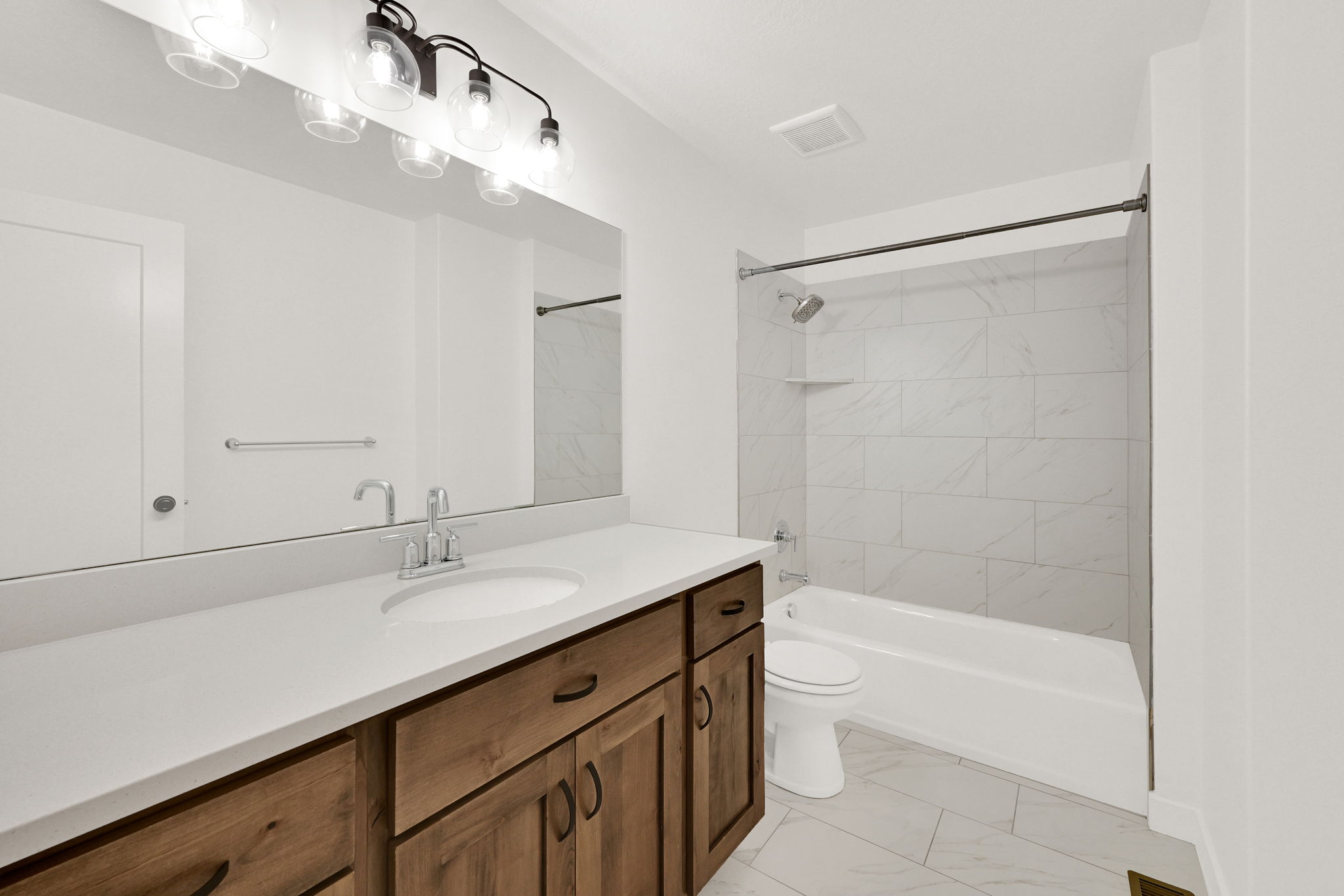 Bathroom featuring a double vanity with wood-finish cabinetry and white countertop