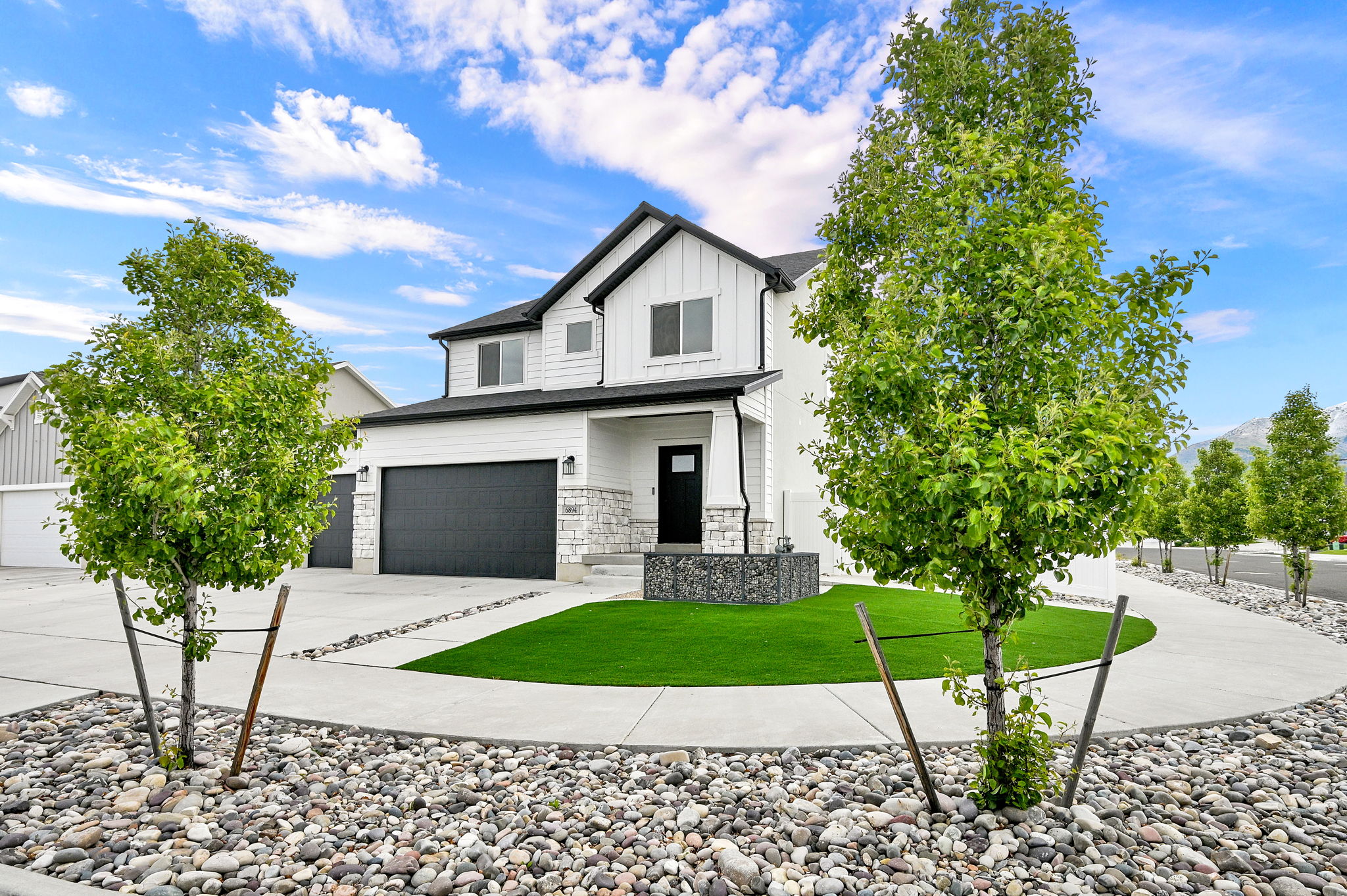 Contemporary two-story residence featuring a white siding exterior with dark trim accents