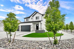 Contemporary two-story residence featuring a white siding exterior with dark trim accents