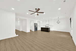 Open-concept living area featuring wood-finish flooring, recessed lighting, and a contemporary ceiling fan