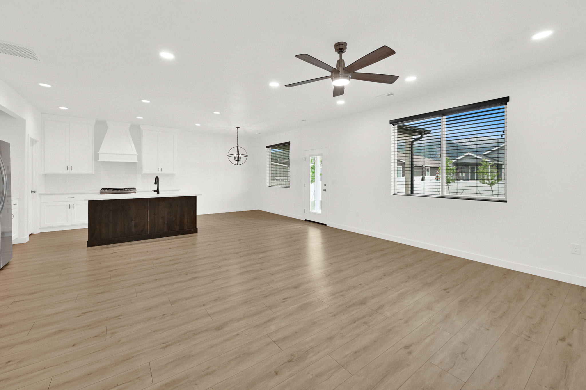 Open-concept living space featuring wood-finish flooring, recessed lighting, and a contemporary ceiling fan
