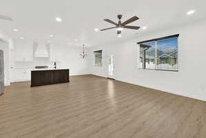 Open-concept living space featuring wood-finish flooring, recessed lighting, and a contemporary ceiling fan