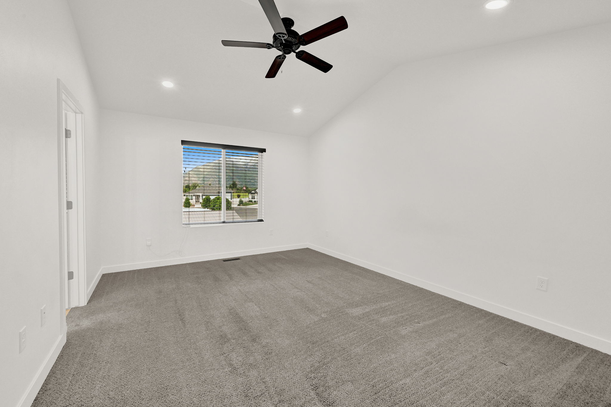 Spacious room featuring vaulted ceilings, recessed lighting, and a contemporary ceiling fan