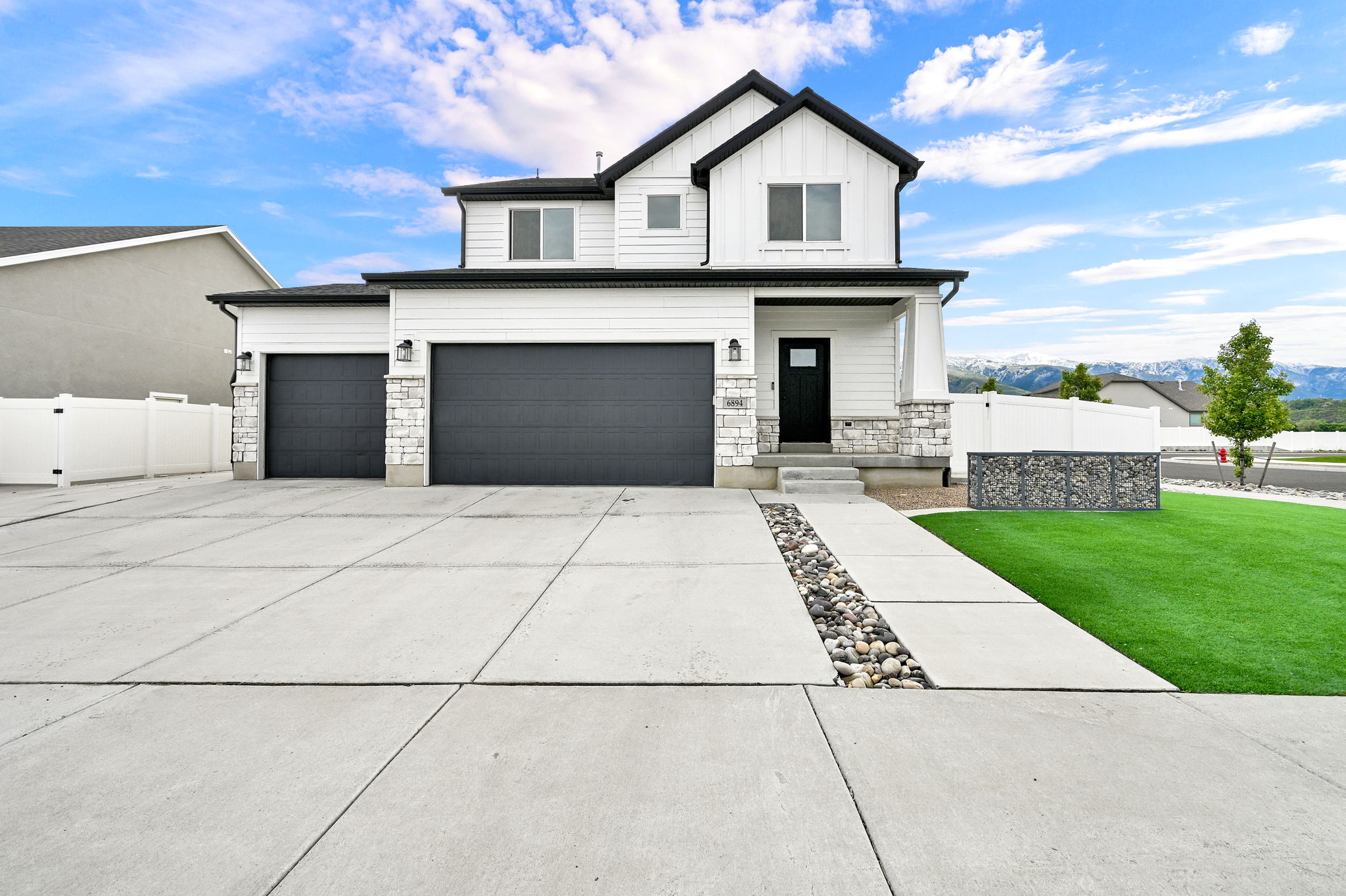 Modern two-story residence featuring white siding and black trim accents