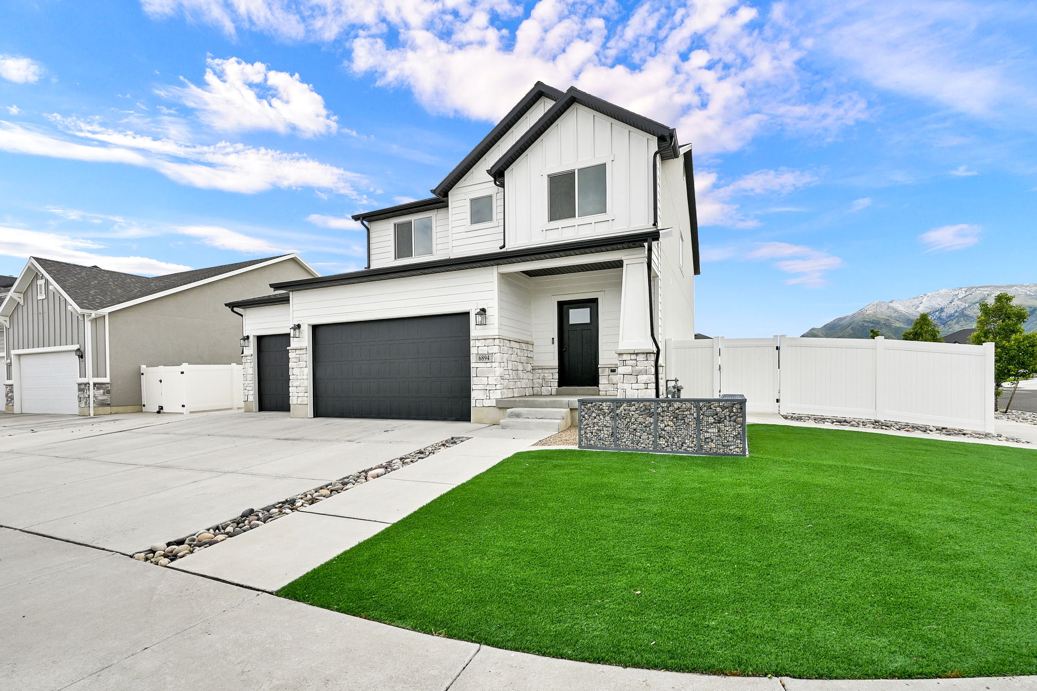 Contemporary two-story residence featuring white siding with black trim accents