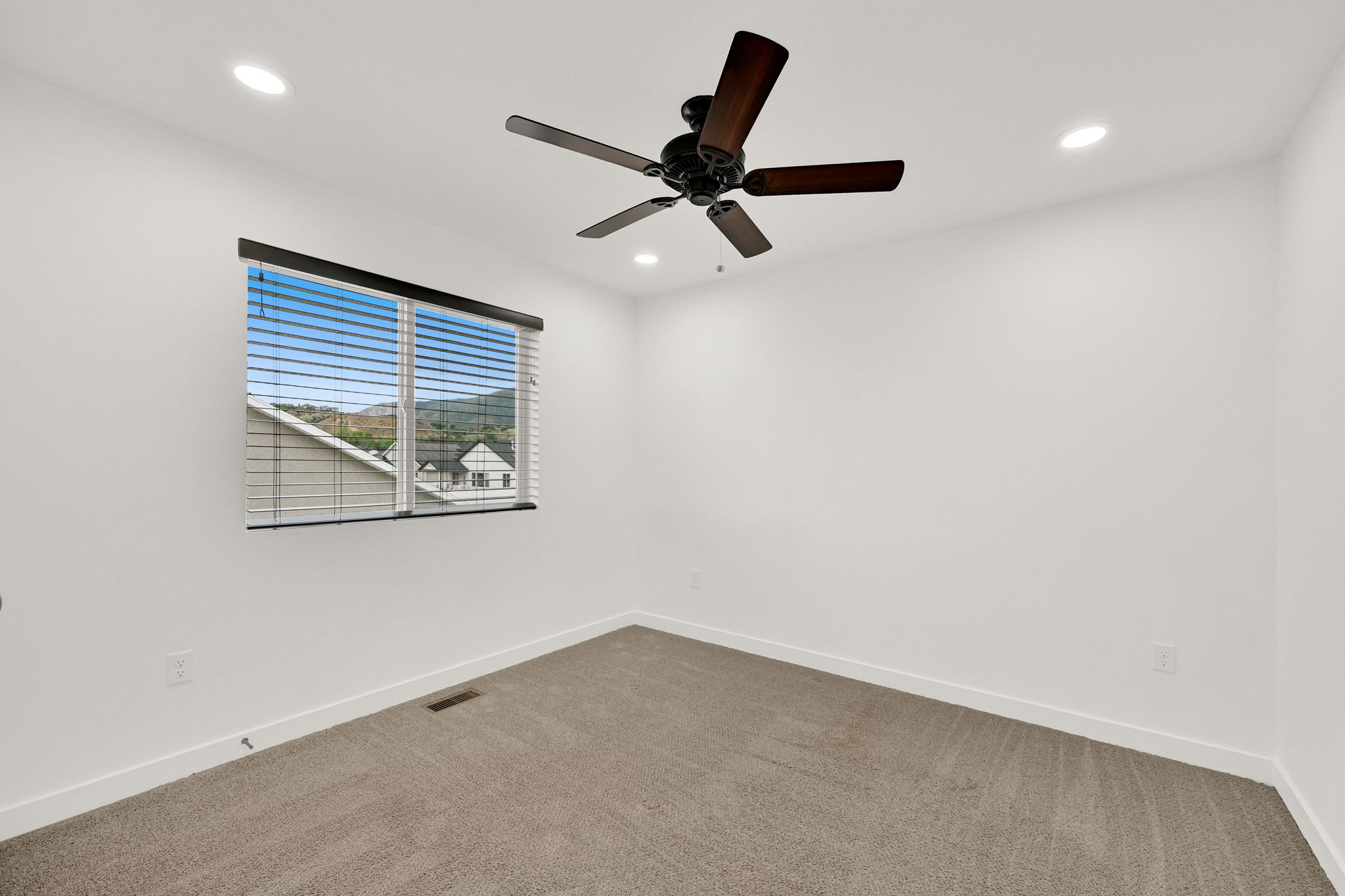 Room featuring a ceiling fan with dark wood-finish blades, recessed lighting, and a window with horizontal blinds