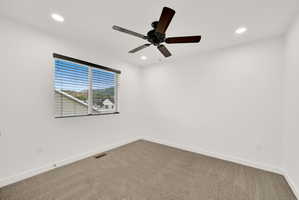Room featuring a ceiling fan with dark wood-finish blades, recessed lighting, and a window with horizontal blinds