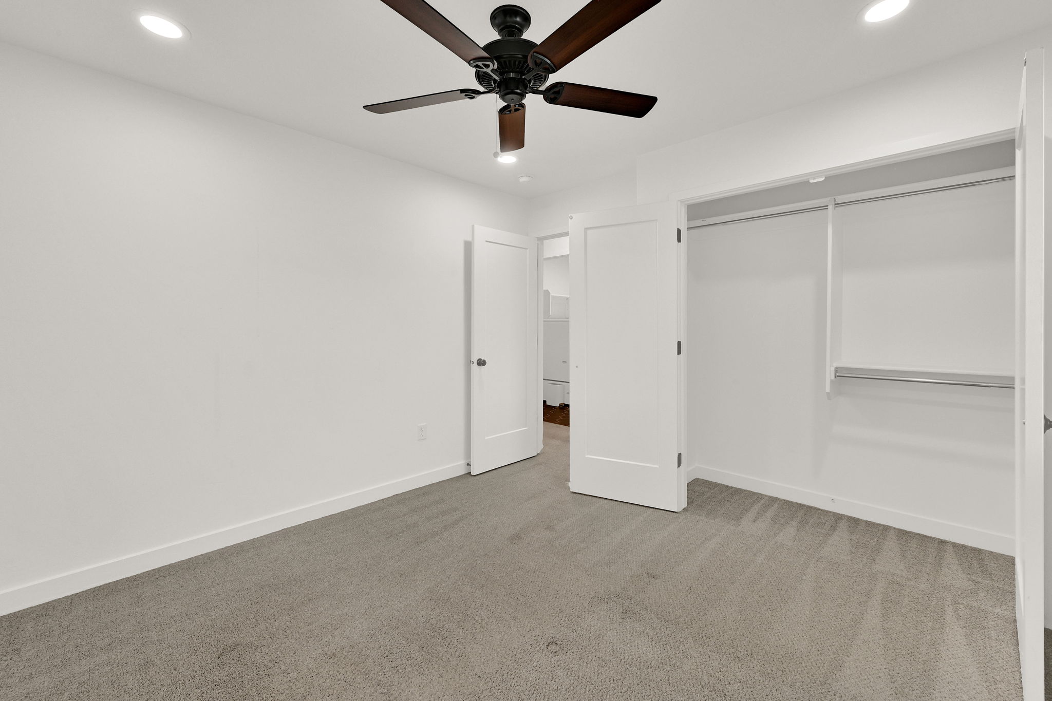 Bedroom featuring gray carpet flooring, white walls, recessed lighting, and a dark wood-finish ceiling fan