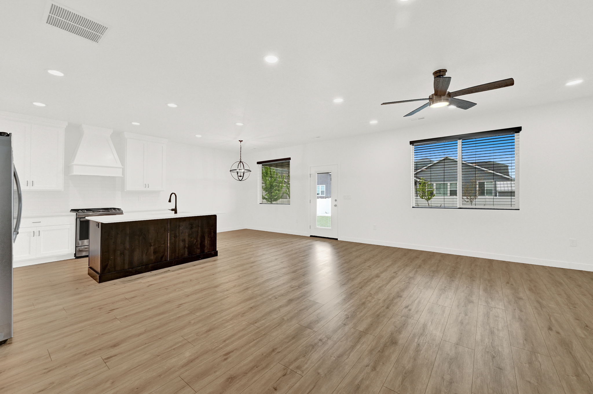 Open-concept living area featuring wood-finish flooring, recessed lighting, and a contemporary ceiling fan