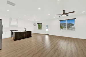 Open-concept living area featuring wood-finish flooring, recessed lighting, and a contemporary ceiling fan