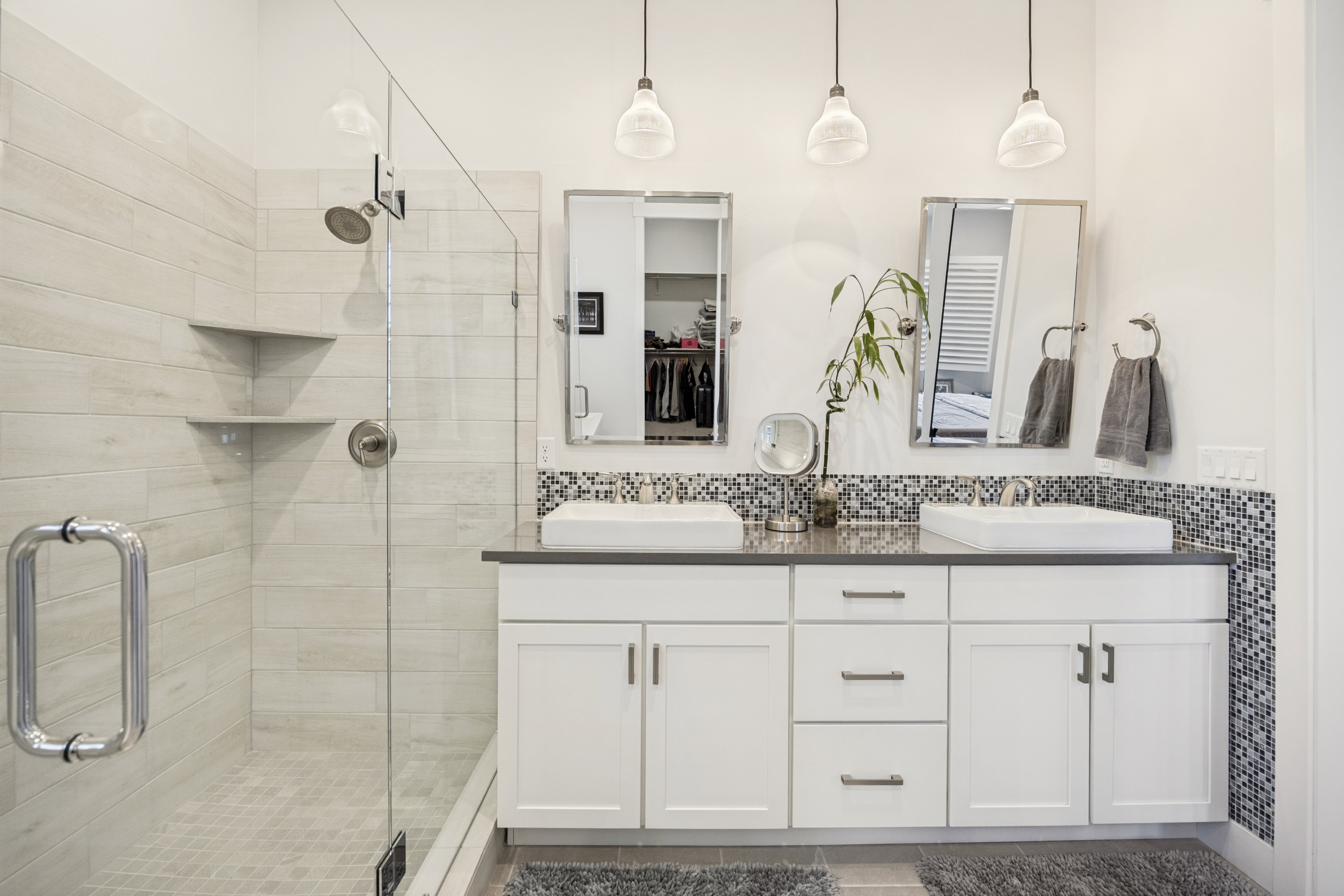 Spacious bathroom featuring a glass-enclosed shower with tiled walls and built-in corner shelving