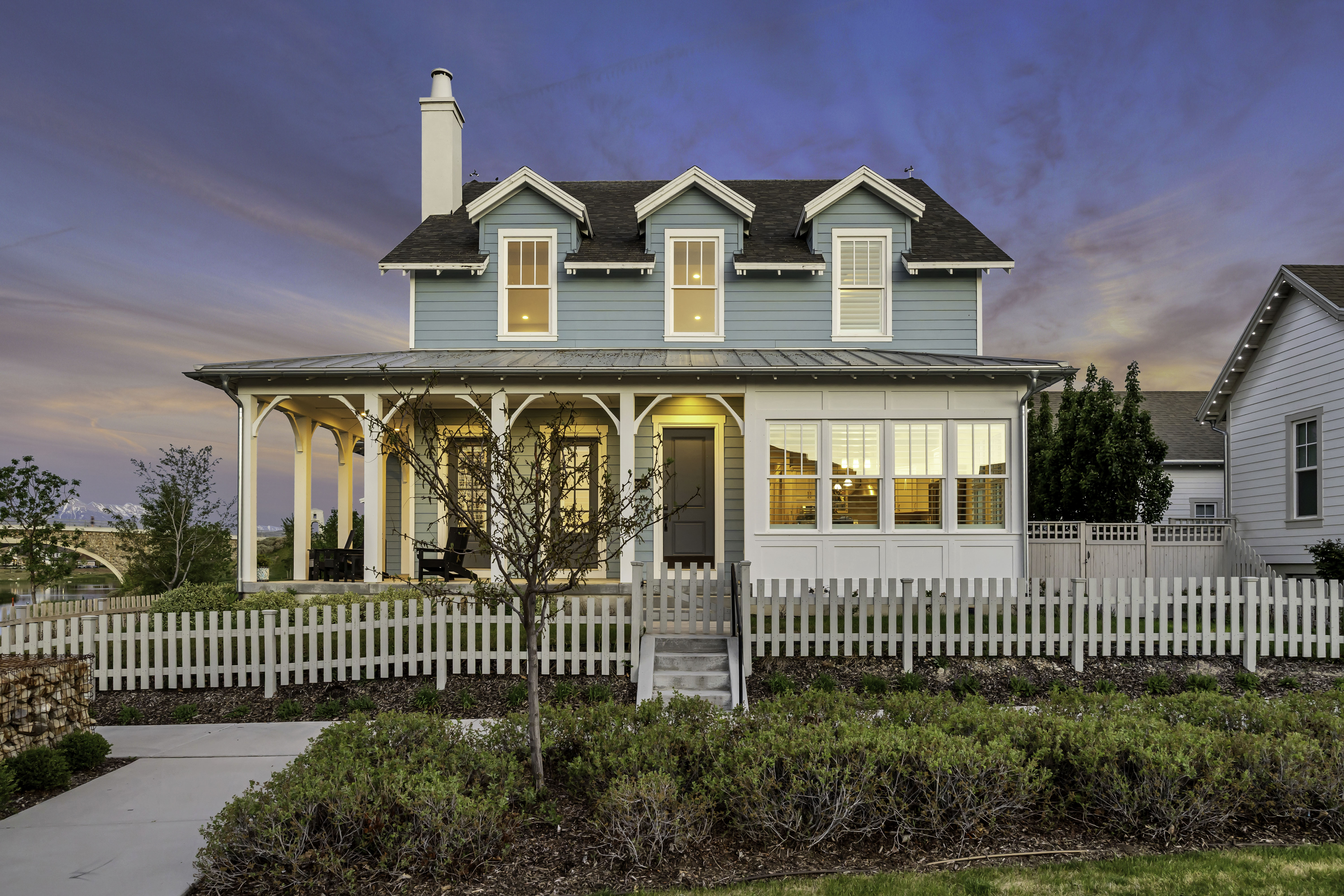Two-story residence featuring light blue siding and a covered front porch with white pillars