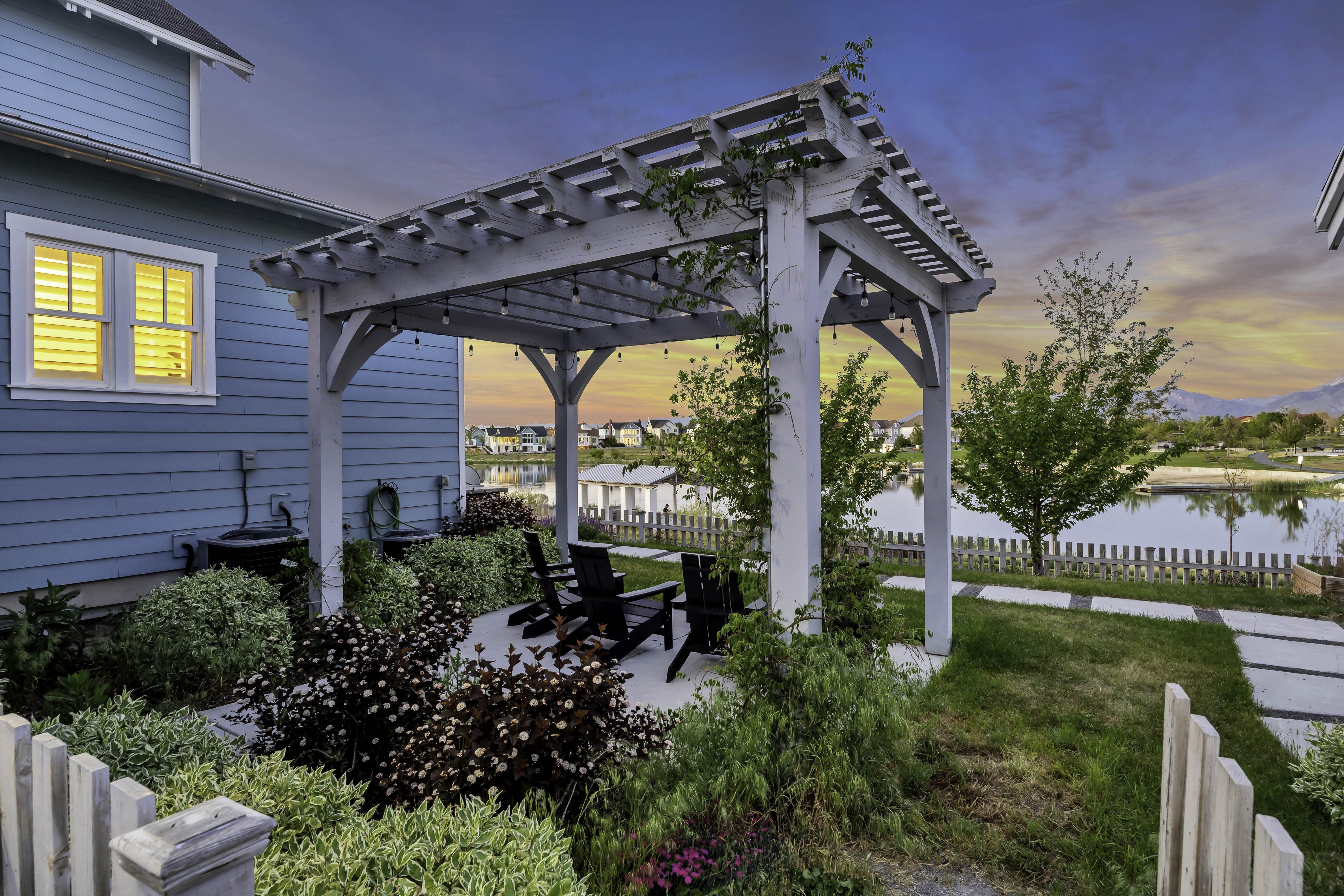 Pergola-covered patio featuring string lighting and a concrete surface
