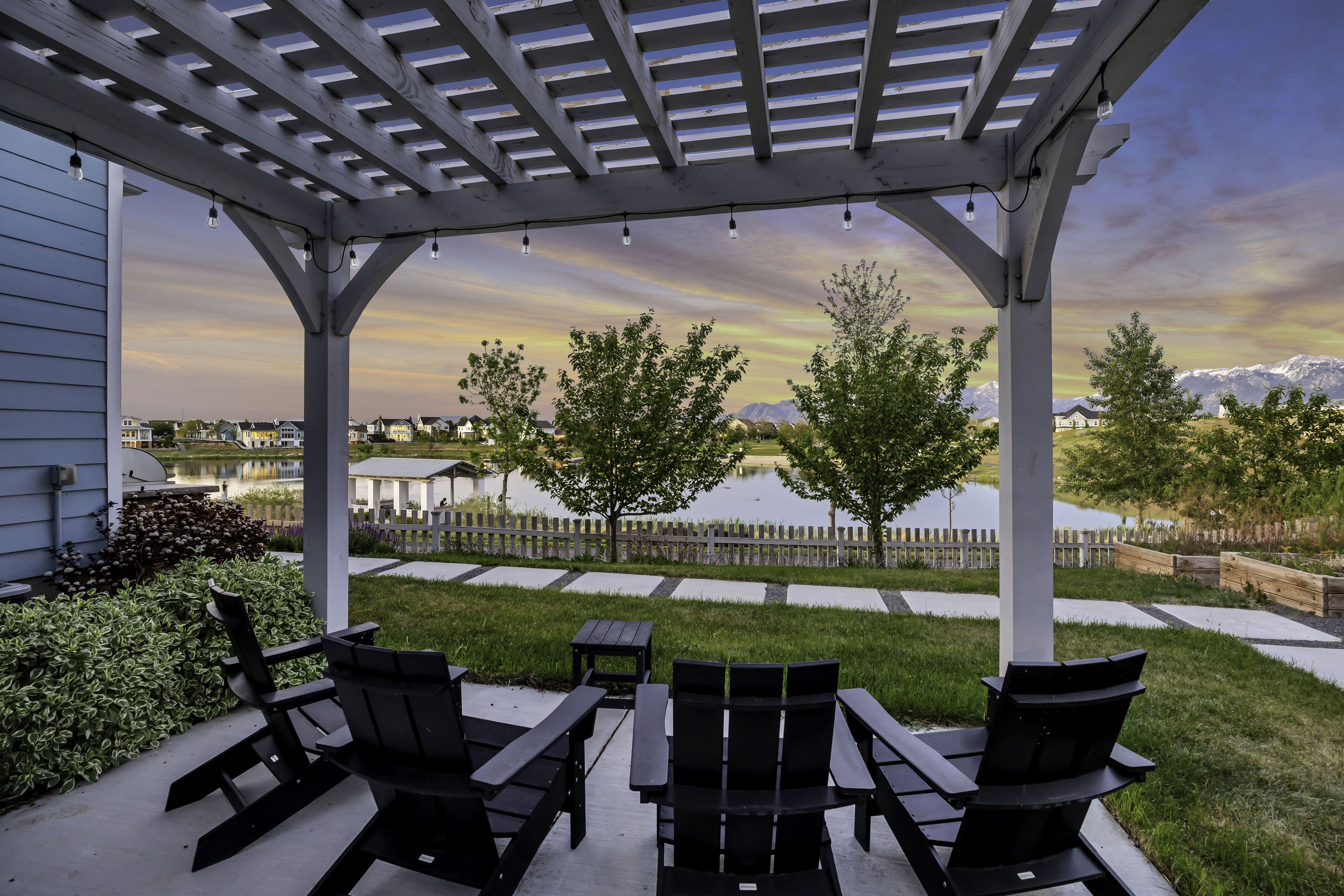 Covered patio featuring string lighting, concrete flooring, and a pergola structure
