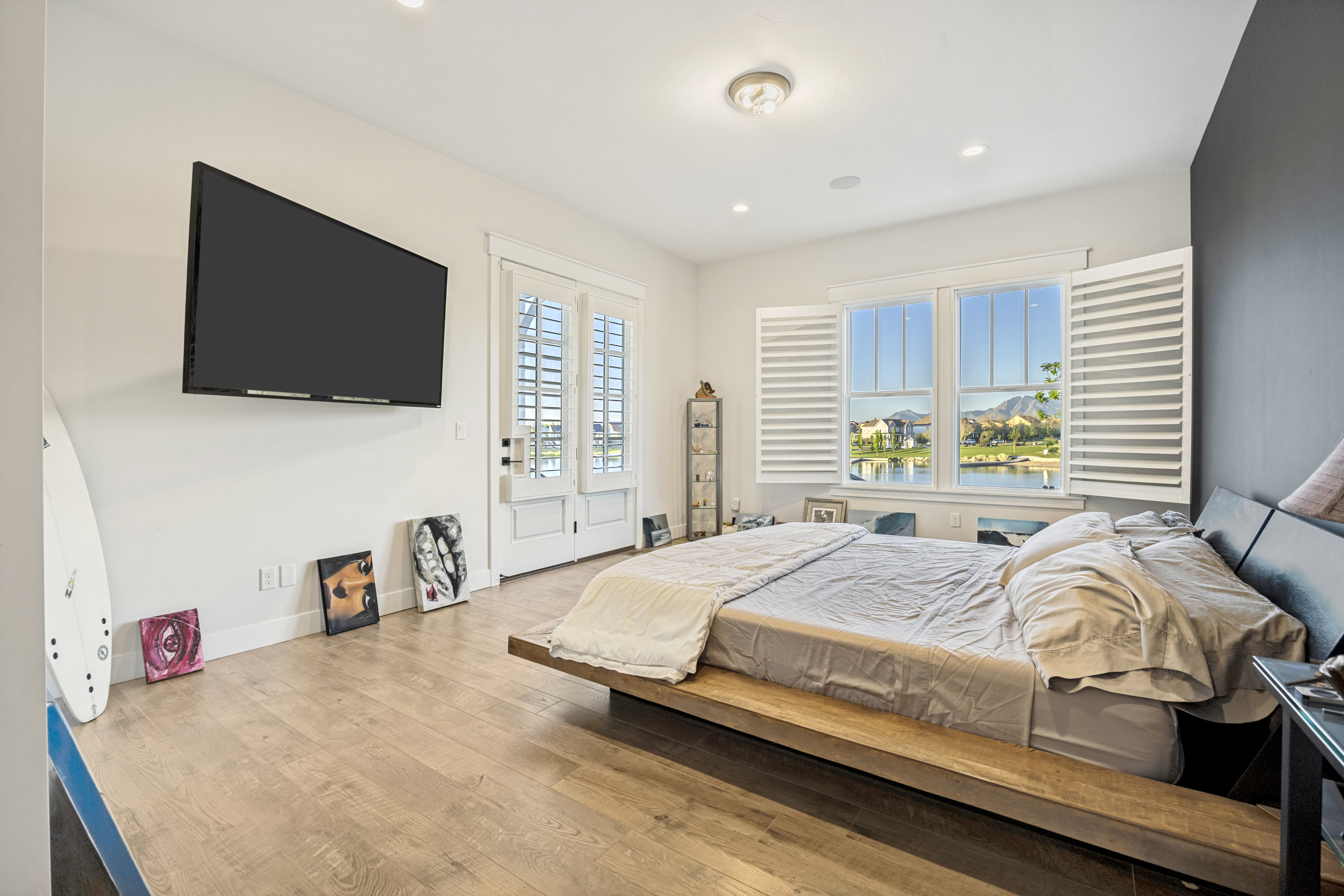 Spacious room featuring wood-finish flooring, white walls, and a contrasting accent wall