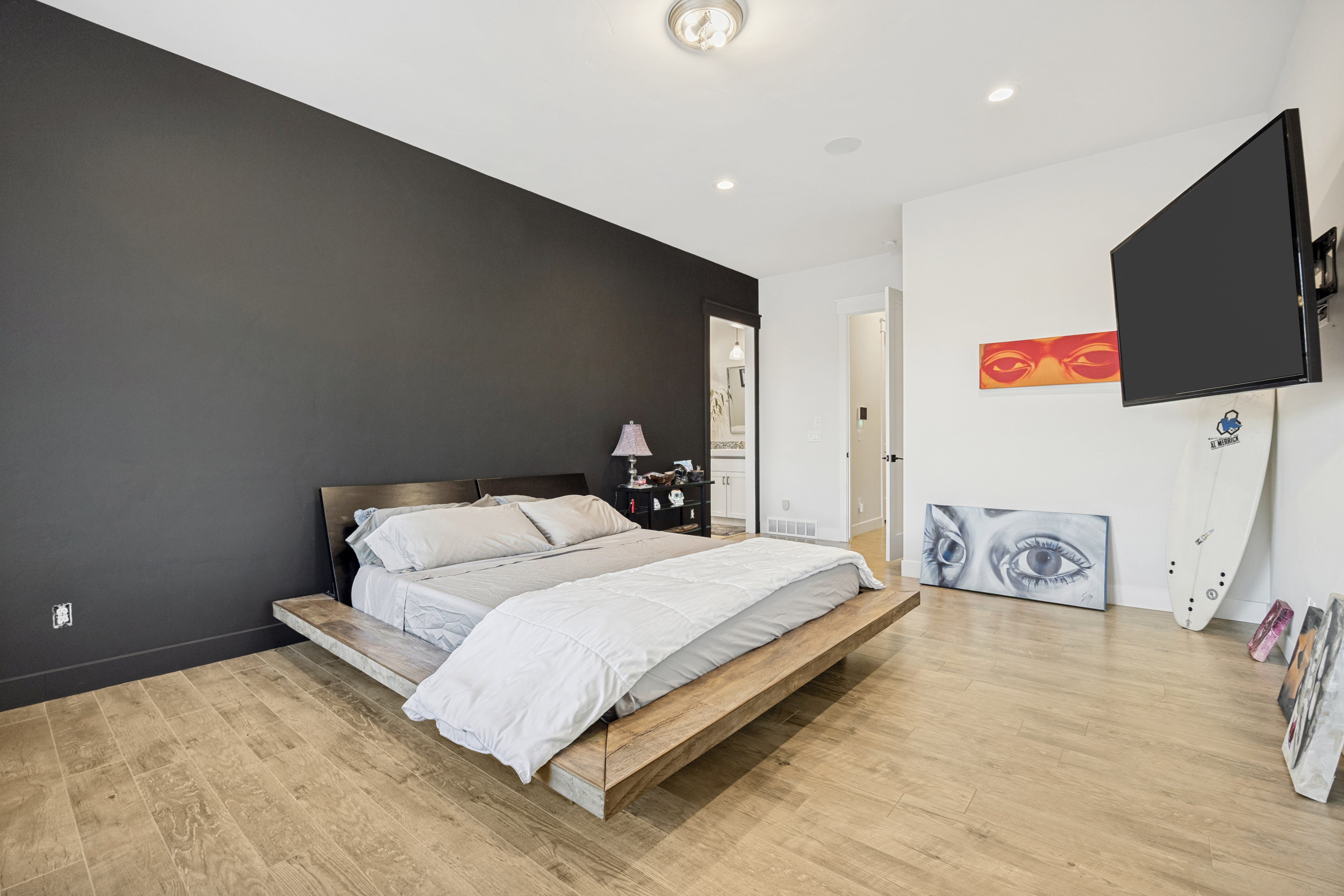 Spacious room featuring wood-finish flooring and a dark accent wall