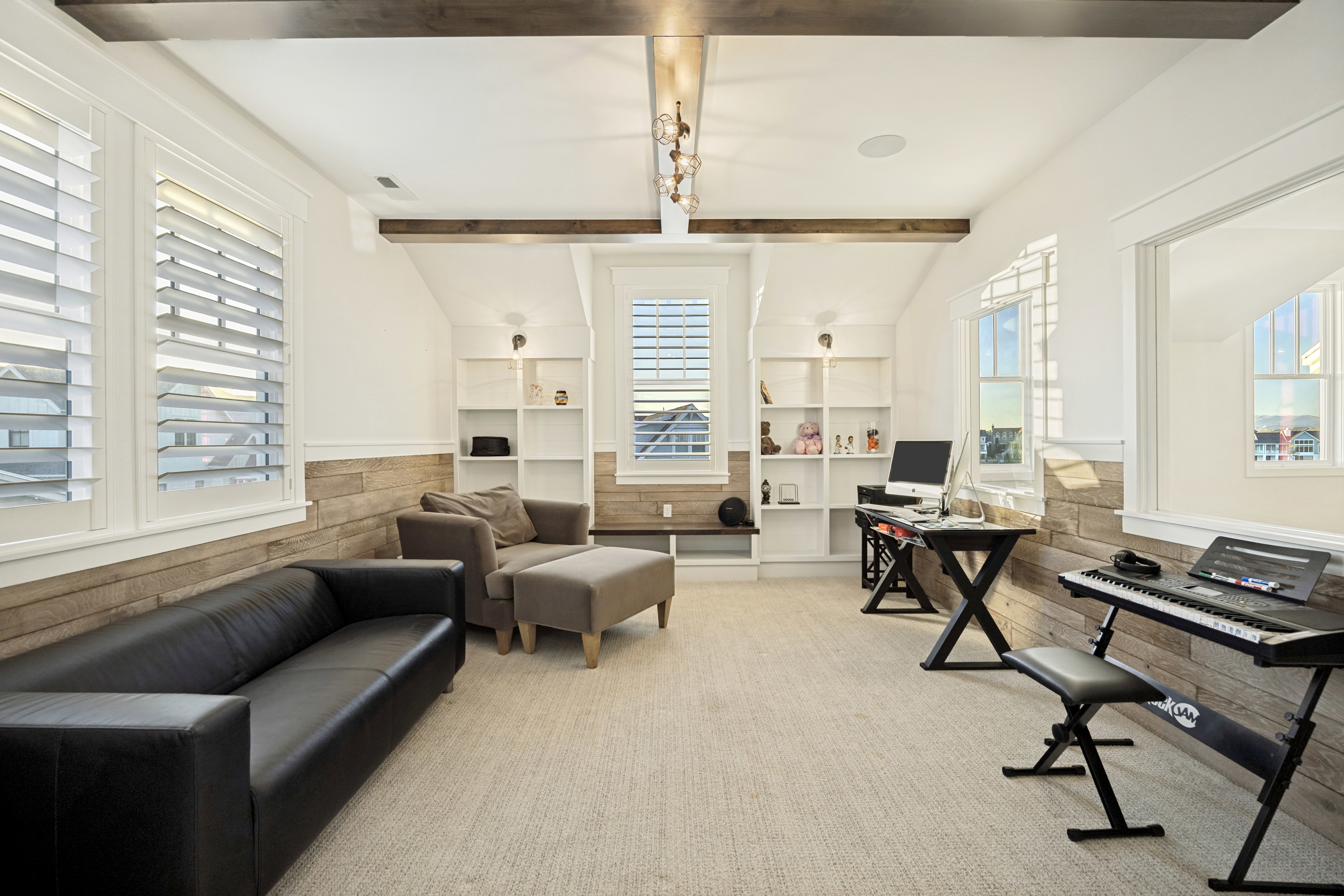 Attic space featuring pitched ceilings, exposed wood beams, and a blend of shiplap and white wall finishes
