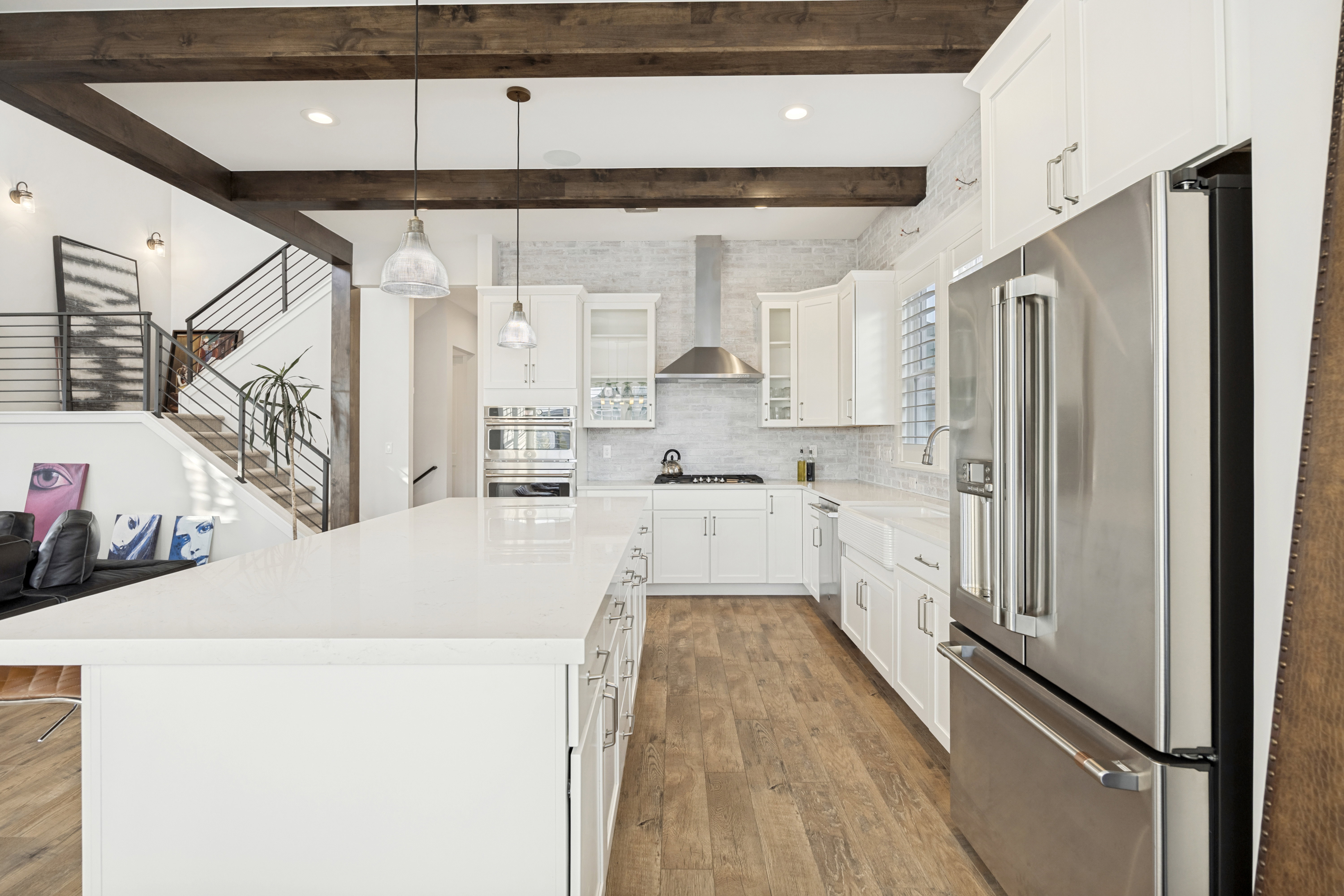 Kitchen featuring a large central island with a solid surface countertop, white cabinetry, and stainless steel appliances