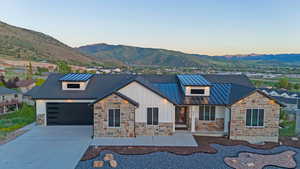 Contemporary ranch-style exterior featuring stone veneer and white vertical siding