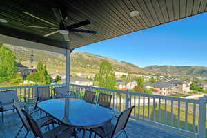 Covered outdoor deck featuring composite wood-finish flooring and white railing