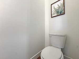 White porcelain toilet with a standard flush lever and a white toilet seat