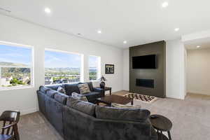 Spacious living area featuring multiple large windows, recessed lighting, and soft carpeting