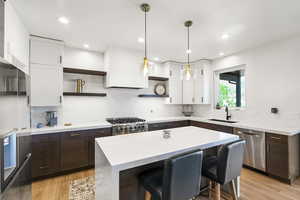 Modern kitchen featuring a waterfall island with a white countertop