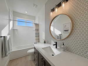 Bathroom vanity featuring a vessel sink, quartz countertop, and dark wood-finish cabinetry