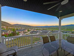 Expansive covered outdoor deck featuring wood-finish flooring and white railings