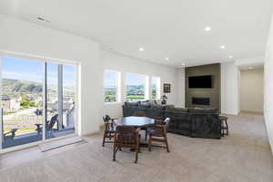 Expansive interior space featuring a recessed fireplace, large sliding glass doors, multiple windows, and recessed lighting